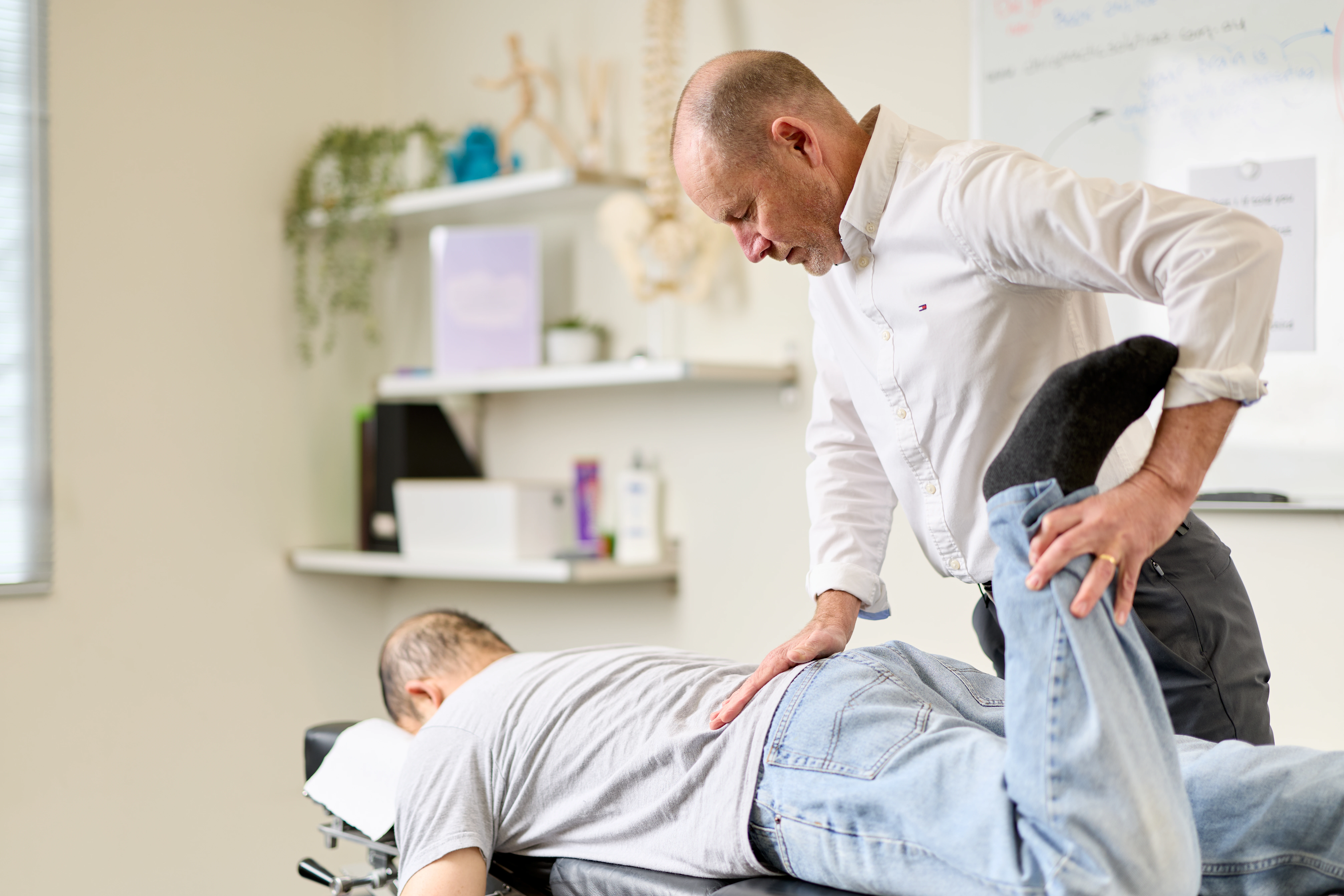 Dr Ken Leembruggen, chiropractor, treating a male patient lying on his stomach. Chiropractic Solutions Norwood Adelaide