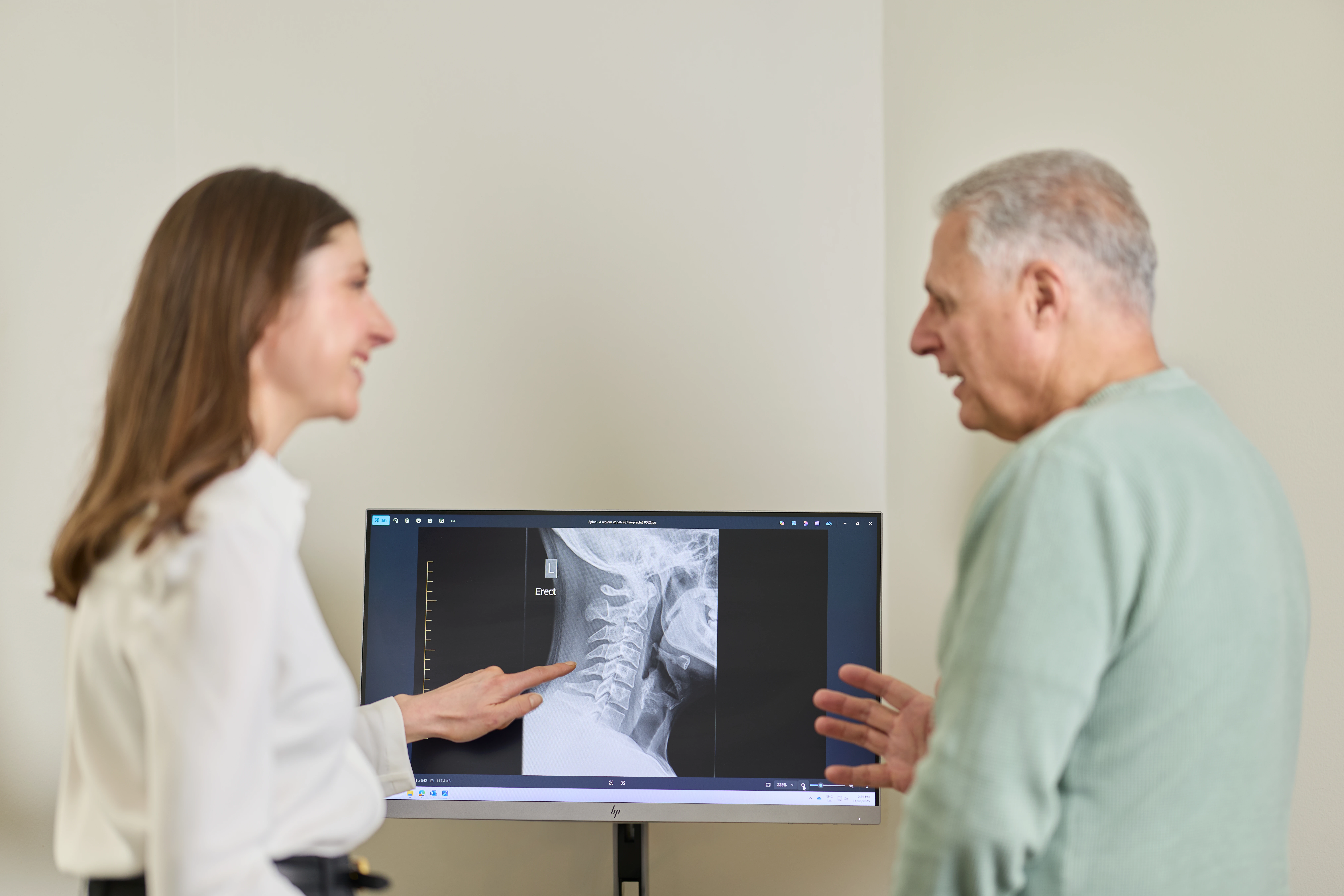 Dr Kimberley Manz, chiropractor, explaining xray findings to a male patient at Chiropractic Solutions Norwood Adelaide